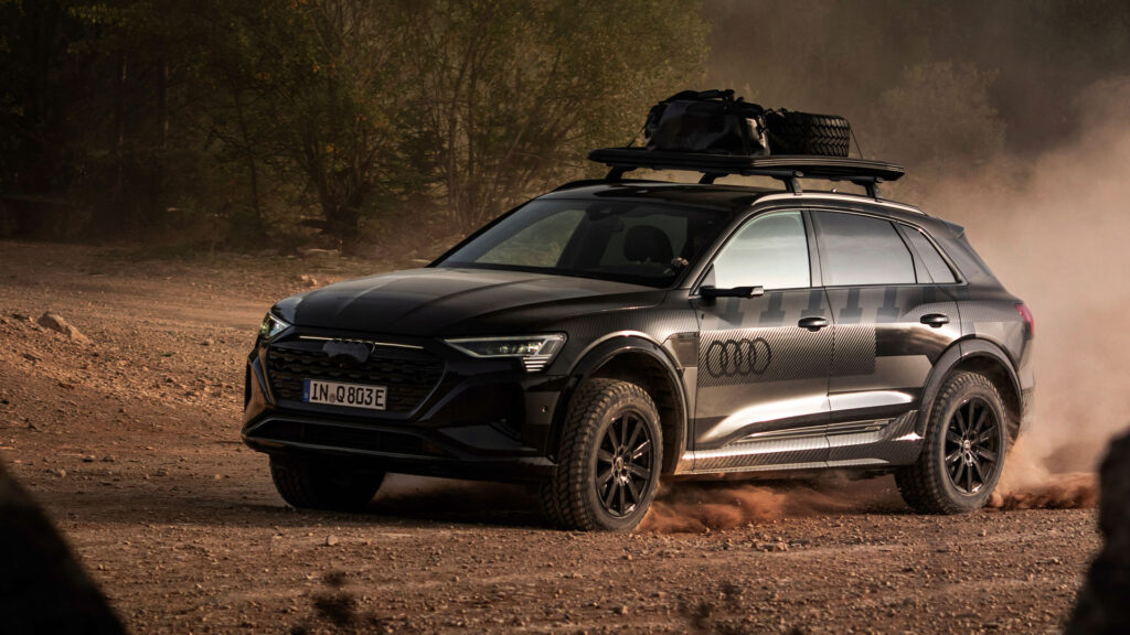 En Audi Q3 SUV kör på en stenig grusväg. (AI text)