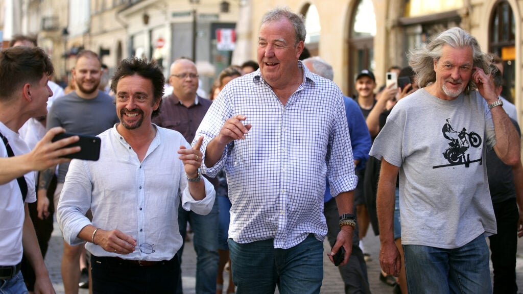 En grupp personer promenerar längs en gata. (AI text)