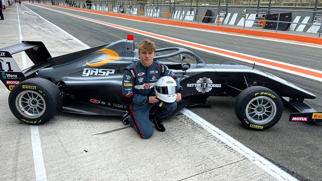 En ung man poserar med sin racerbil. (AI text)