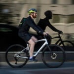 En man cyklar på en stadsgata. (AI text)