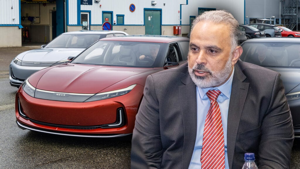 En man i kostym sitter framför en bil. (AI text)