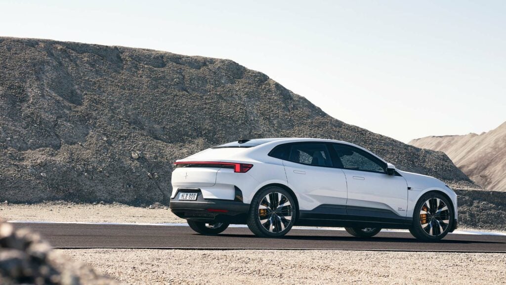 En vit elbil kör längs en ökenväg. (AI text)