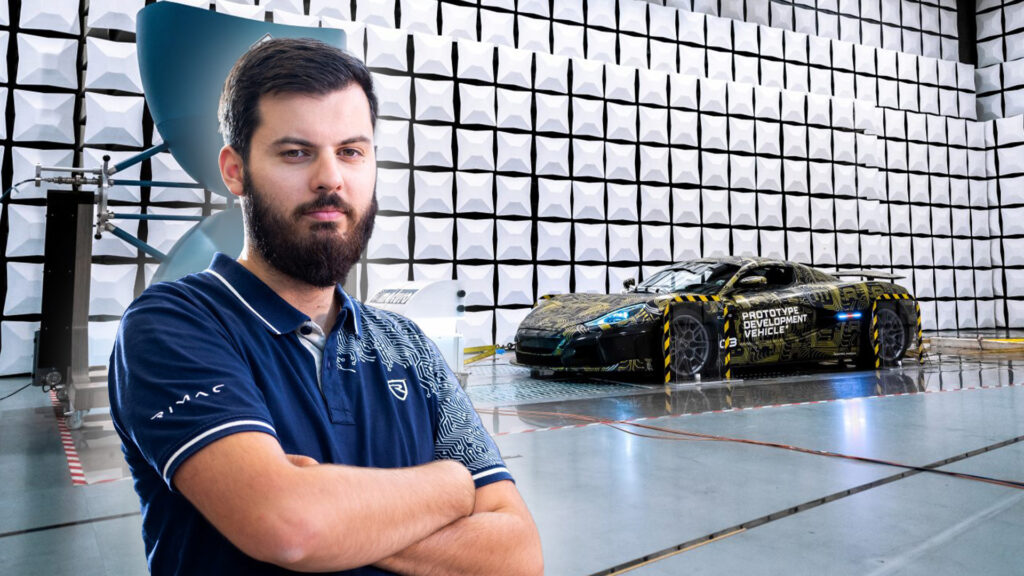 En man står framför en bil i en garage. (AI text)