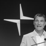 En man talar från ett podie. (AI text)