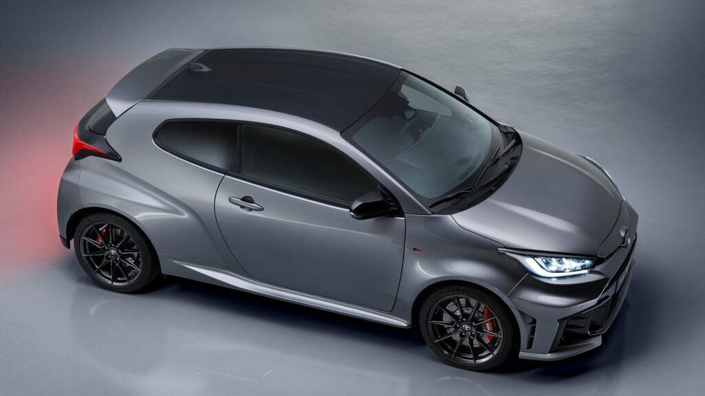 Toyota iQ-hackaren visas på en grå bakgrund. (AI text)