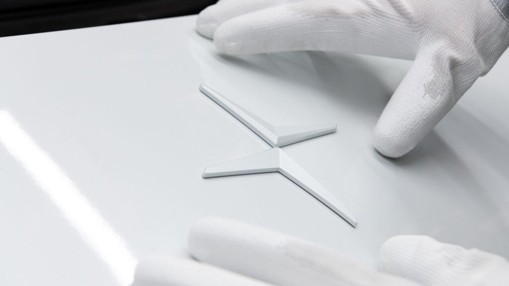 En person sätter en etikett på en bil. (AI text)