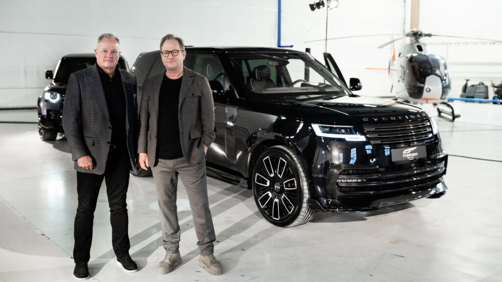 Två män står bredvid en Range Rover. (AI text)