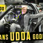 En man står framför en bil. (AI text)