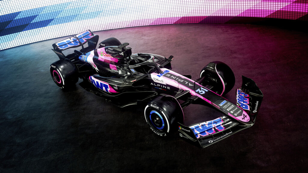 En racerbil i en mörk rum med rosa och lila ljus. (AI text)