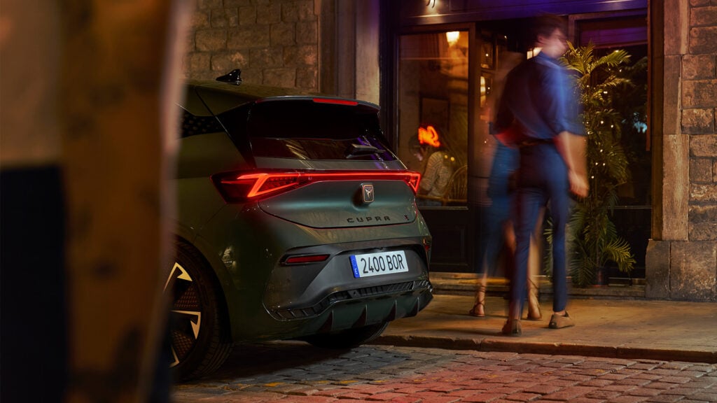 En man och kvinna står bredvid en bil på natten. (AI text)