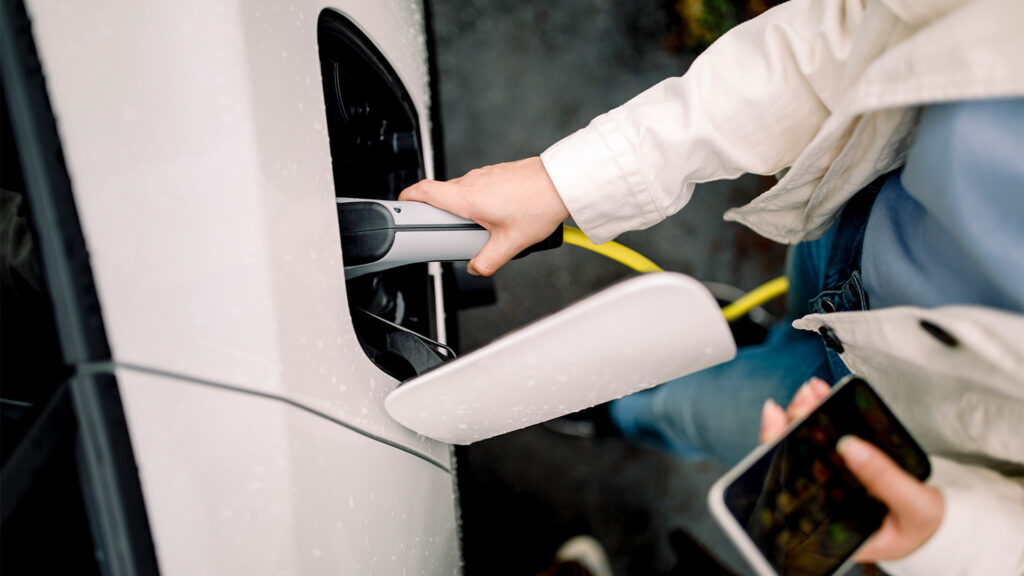 En kvinna laddar sin bil. (AI text)