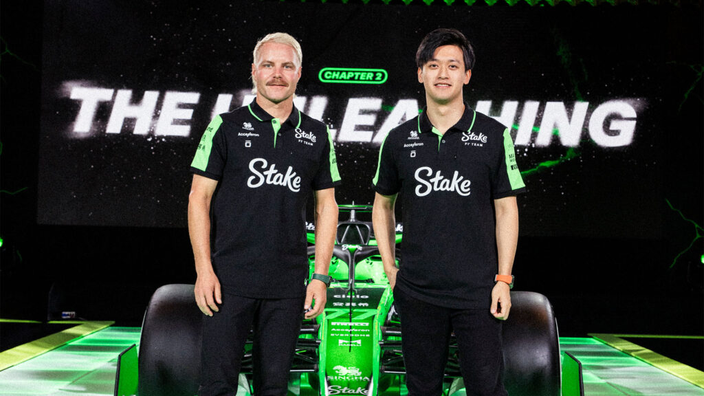 Två personer står bredvid en grön tävlingsbil. (AI text)