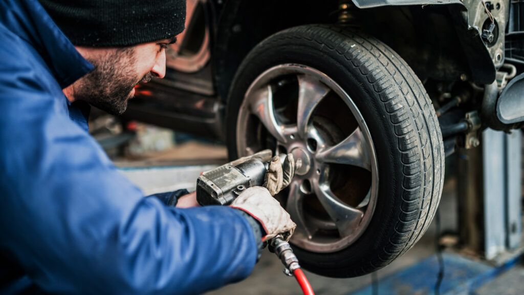 En mekaniker arbetar med en biljakes. (AI text)