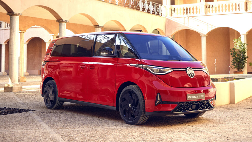 En röd Renault EV parkerad framför ett byggnad. (AI text)