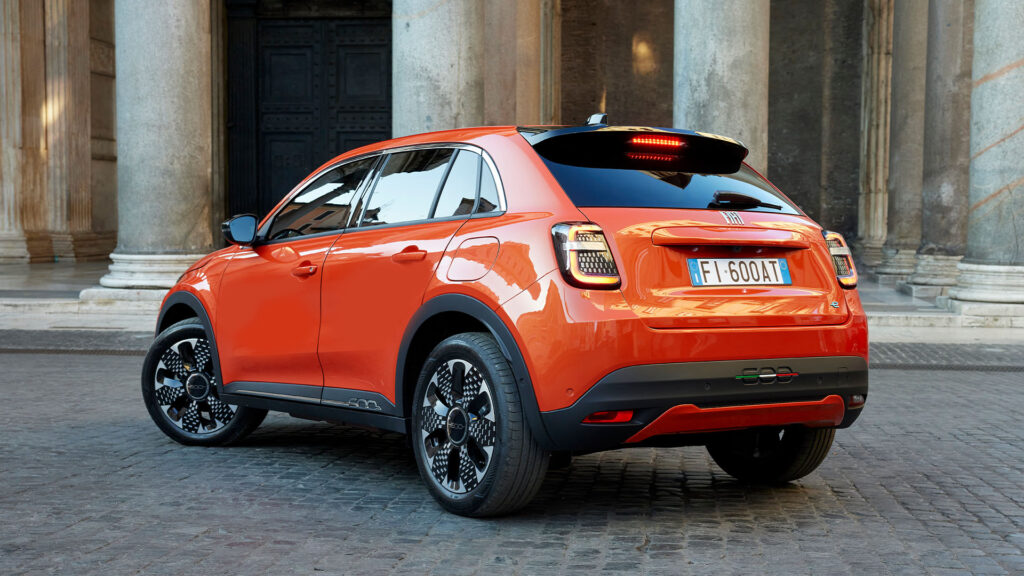 En bil parkerad framför ett byggnad. (AI text)