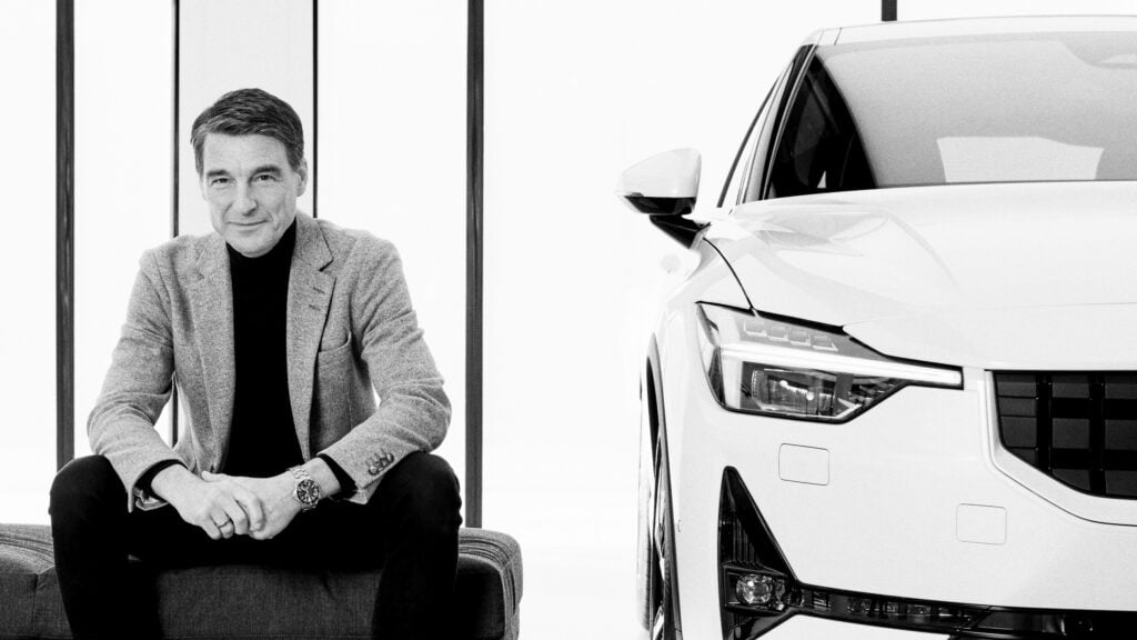 En man sitter på en stol bredvid en bil. (AI text)