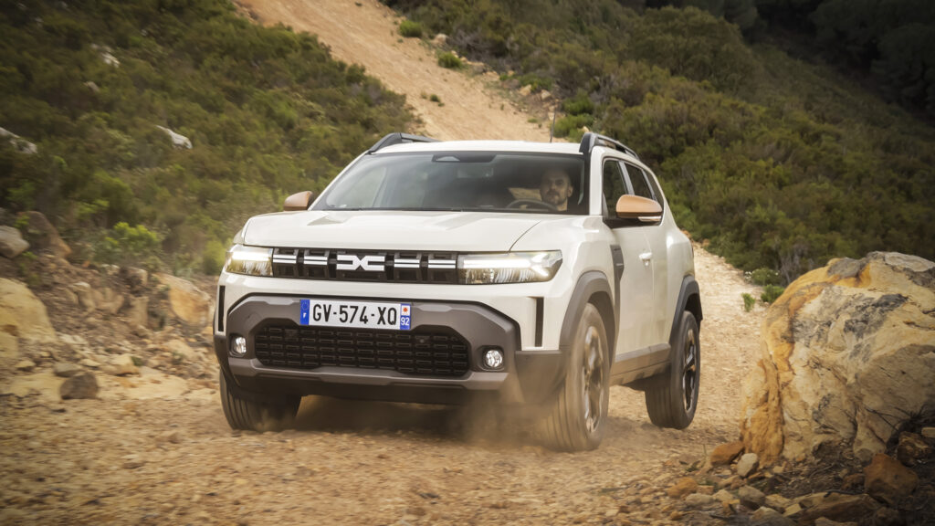 En vit fyrhjulsdriven bil kör nerför en grusväg. (AI text)