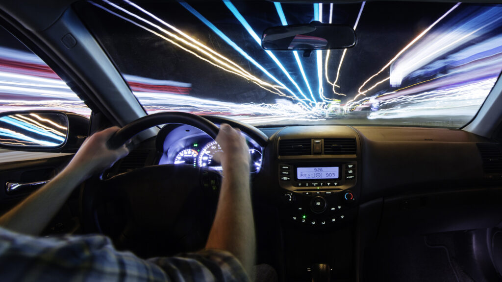 En man kör en bil på natten. (AI text)