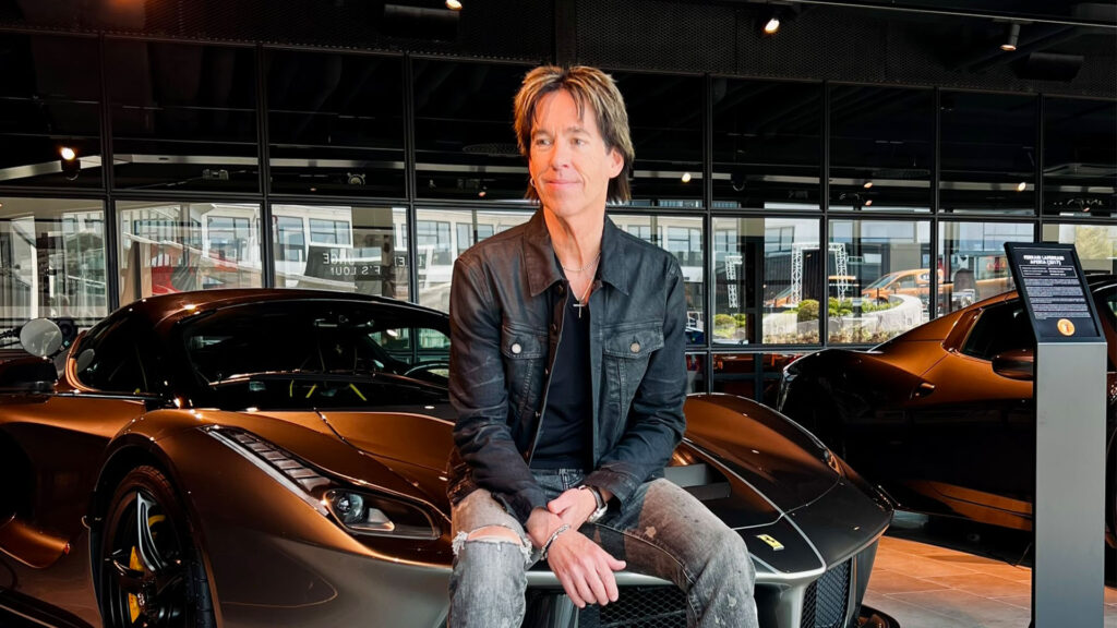 En man sitter på en bil i en showroom. (AI text)