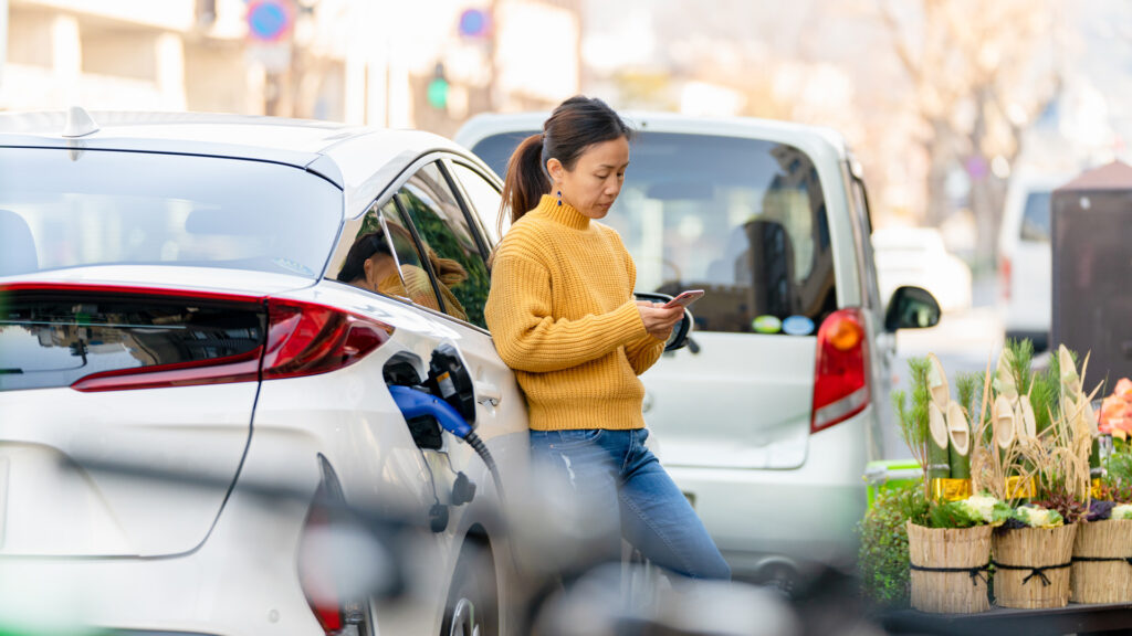 En kvinna använder sin telefon för att kontrollera statusen på hennes bil. (AI text)