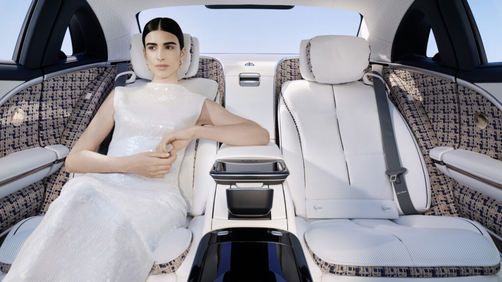 En kvinna i ett vitt klänning sitter i bakluckan av en bil. (AI text)