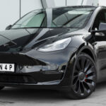 Tesla Model Y parkerad framför ett byggnad. (AI text)