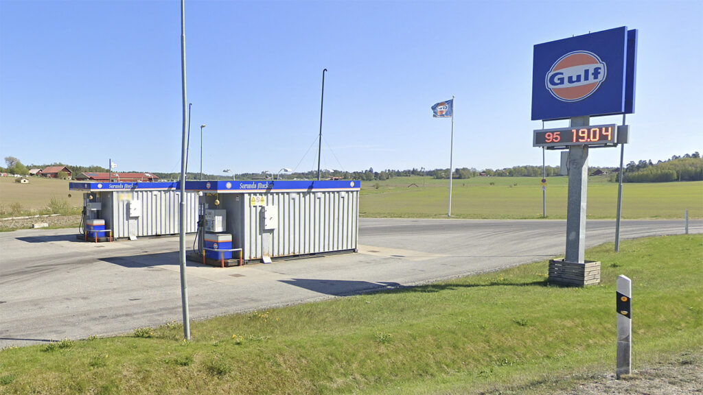 En bensinstation med en skylt. (AI text)