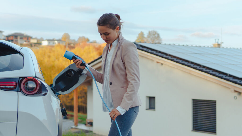 En kvinna laddar sin elbil. (AI text)