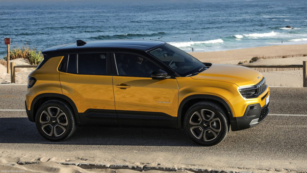 En gul SUV kör ner på en strandväg. (AI text)