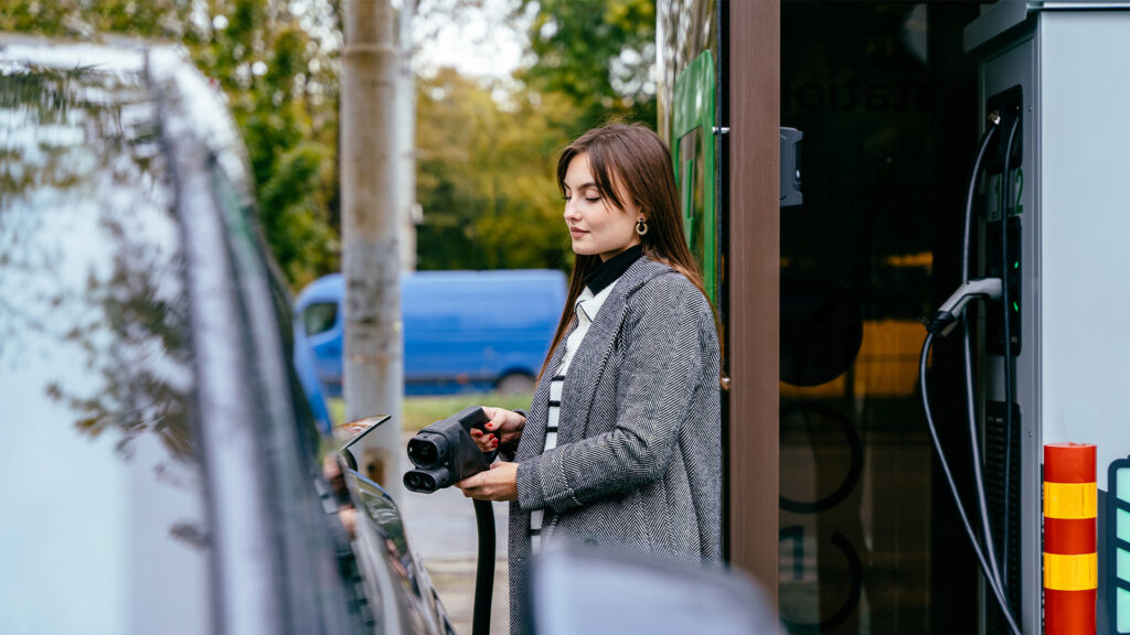 En kvinna fyller på bilens bränsle. (AI text)