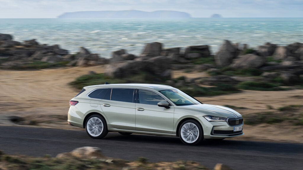 En Skoda Polo kombi kör längs en väg vid havet. (AI text)