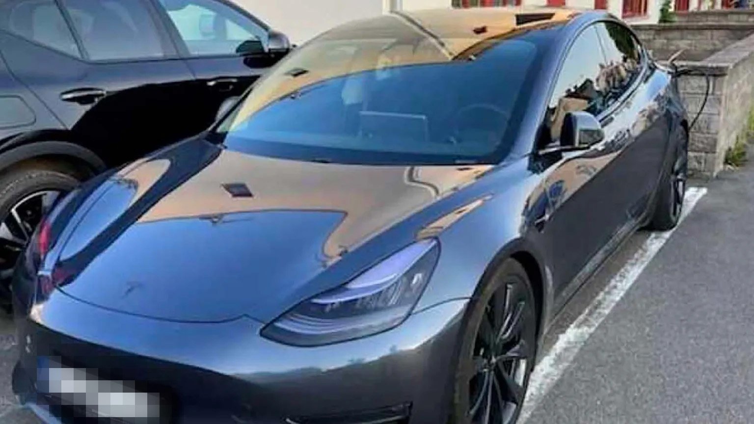En Tesla Model 3 parkerad framför ett byggnad. (AI text)