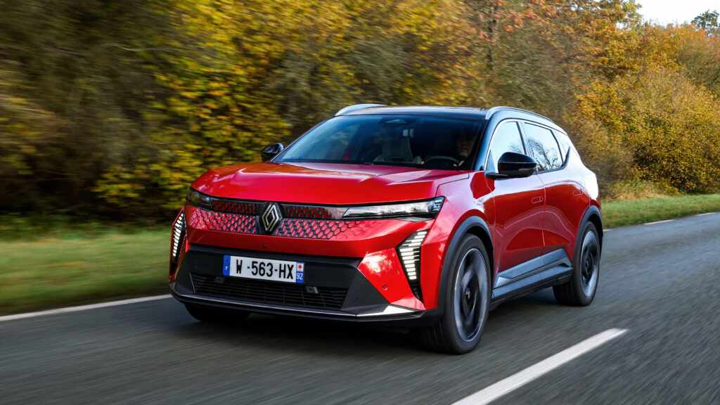 En röd Renault ECV kör nerför en landsväg. (AI text)