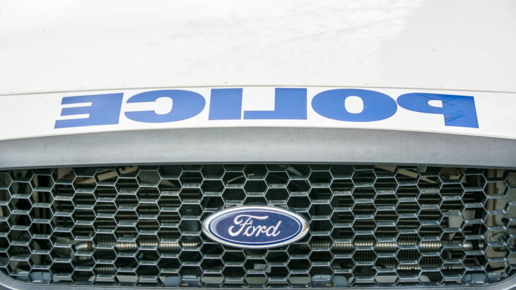 En polisbil med ett polisemblem på grillen. (AI text)