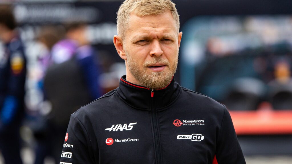 En racerförare och en mekaniker står på banan. (AI text)