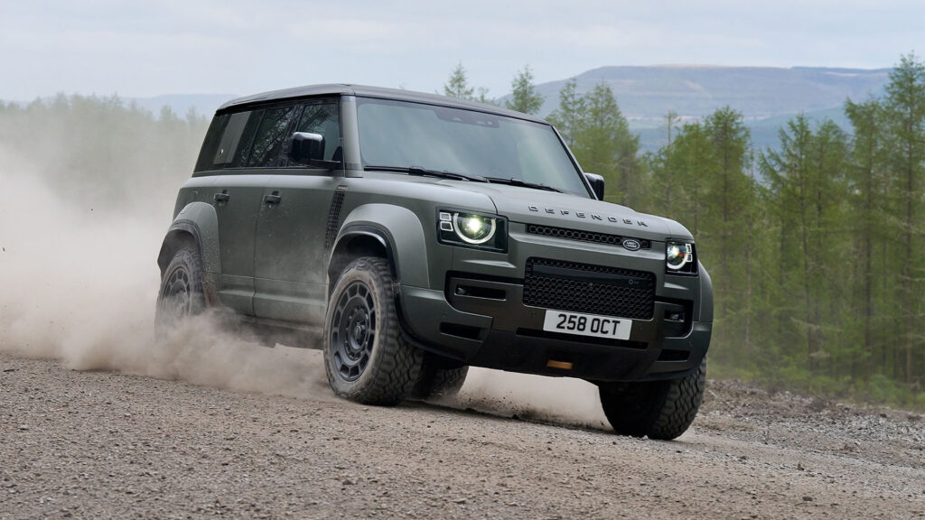 En Land Rover Defender kör nedför en grusväg. (AI text)