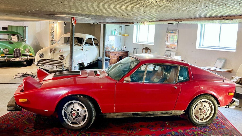 En röd bil i en garagelänga. (AI text)