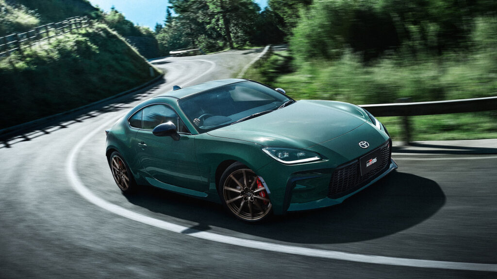 Toyota GT86 är en grön sportbil som kör nerför en bergväg. (AI text)