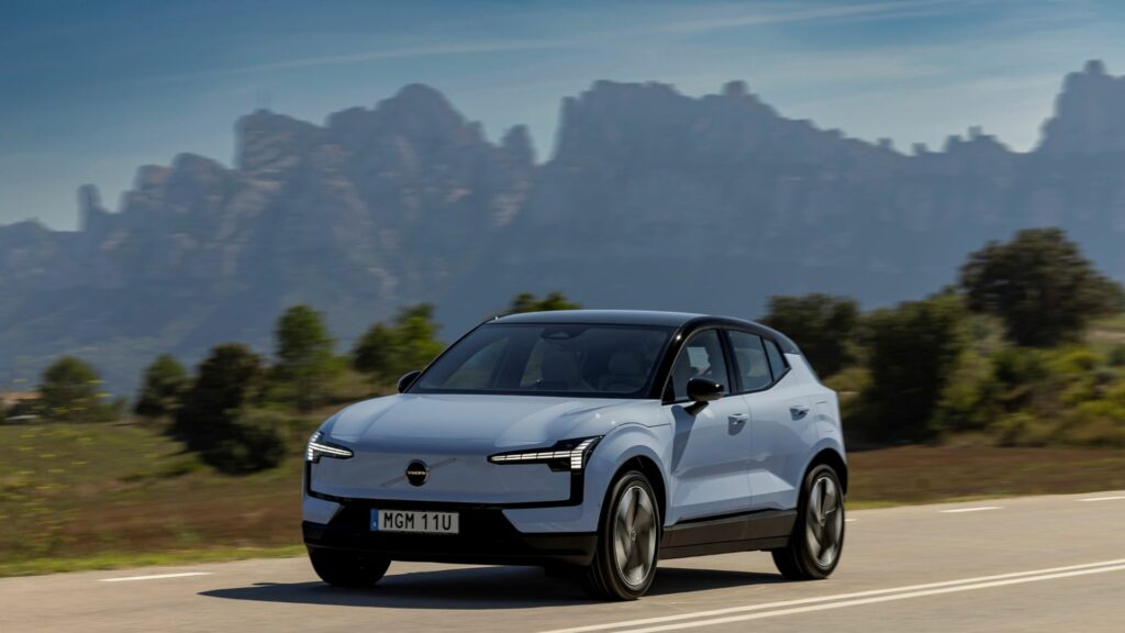 En blå elbil kör nerför en bergsväg. (AI text)