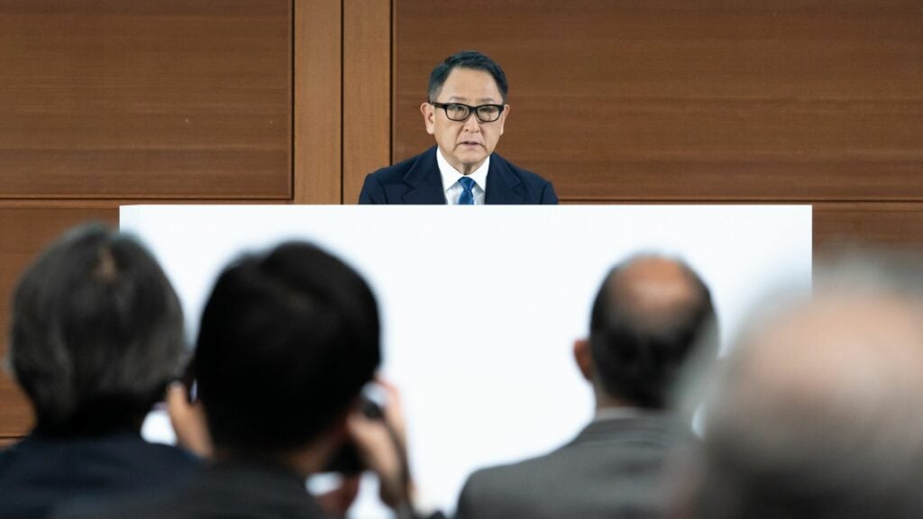 En man talar från ett pultborde. (AI text)