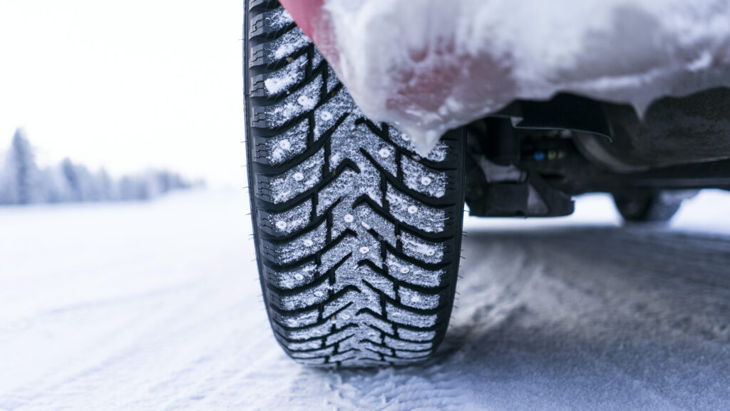 En bil kör på en snöig väg. (AI text)