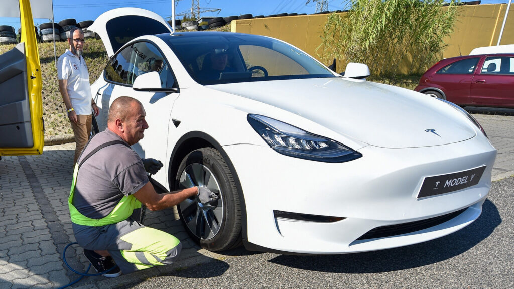 Tesla Model S parkerad vid laddstation (AI text)