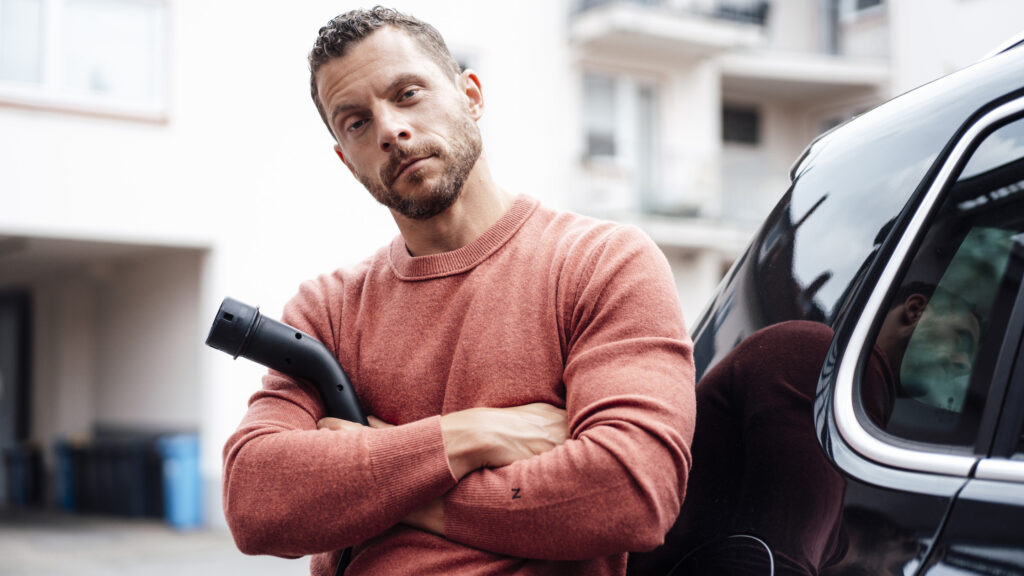 En man står bredvid sin bil. (AI text)