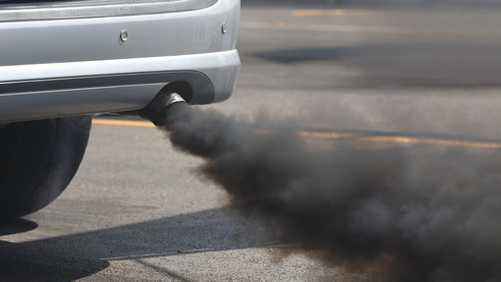 En bil släpper svart rök från sin utluftningsanordning. (AI text)