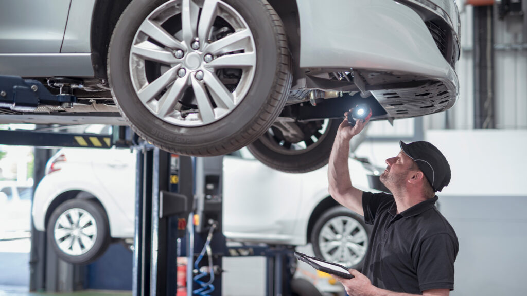 En mekaniker granskar en bil i en garage. (AI text)