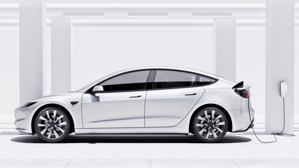 Tesla Model 3 laddar i en garage. (AI text)