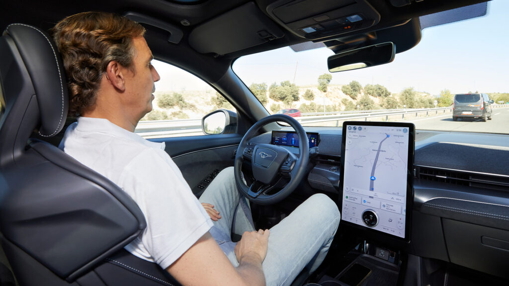 En man kör en bil med ett självkörande system. (AI text)