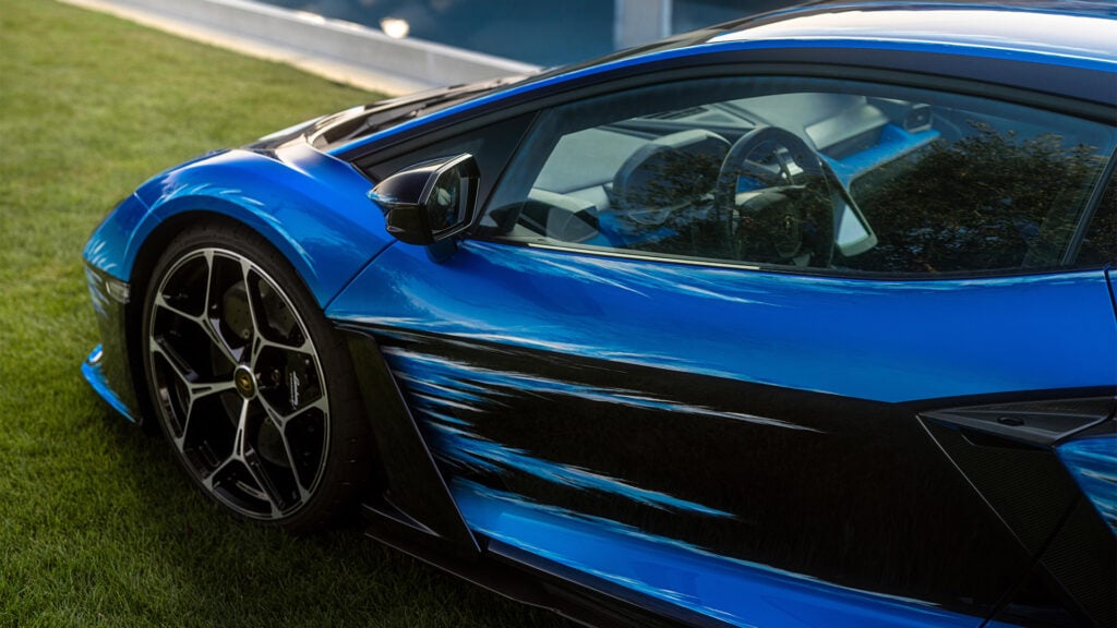 En blå Lamborghini Huracán parkerad på gräset. (AI text)