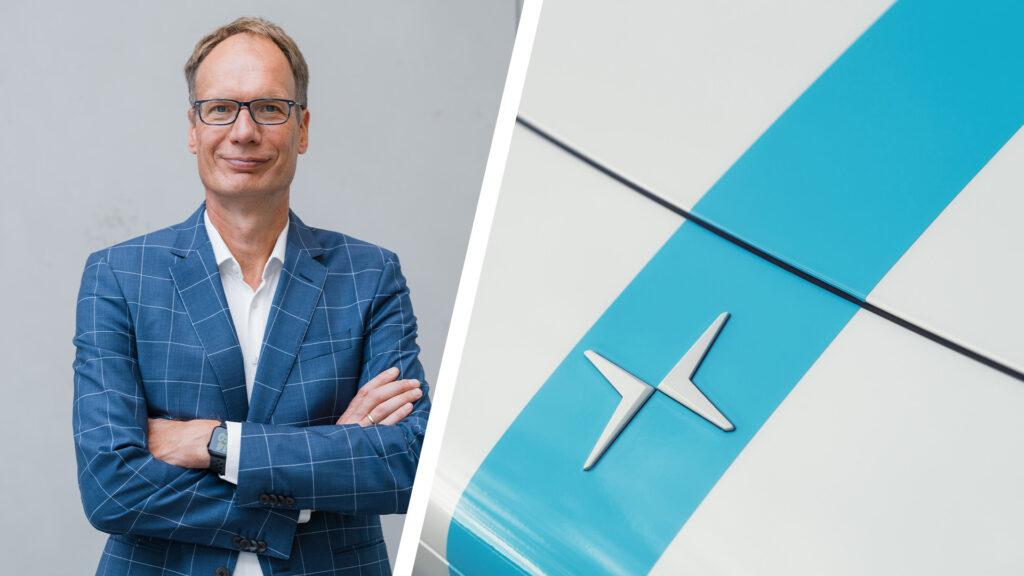 En man i kostym och slips står bredvid en blå och vit bil. (AI text)