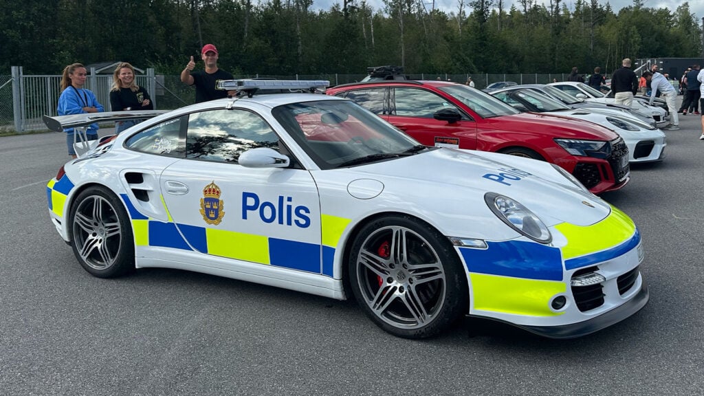 En grupp parkerade polisbilar på en parkeringsplats. (AI text)